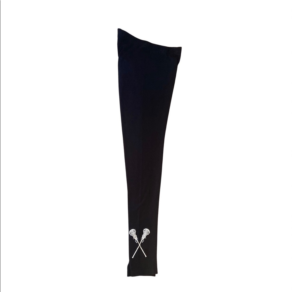 Black leggings, white lacrosse sticks on side of one leg.